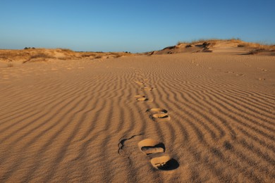 Trail of footprints on sand in desert