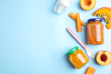 Flat lay composition with healthy baby food and ingredients on light blue background. Space for text