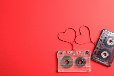 Music cassettes and hearts made of tape on red background, flat lay with space for text. Listening love songs