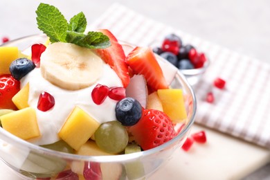 Delicious fruit salad with yogurt in bowl, closeup