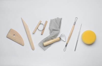 Photo of Set of clay modeling tools on white background, flat lay