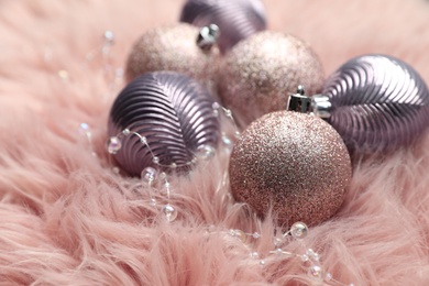 Beautiful Christmas baubles on pink faux fur, closeup