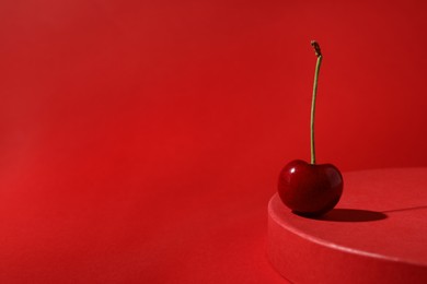Sweet ripe cherry on red table, space for text