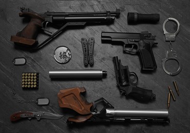 Flat lay composition with different guns on dark table