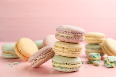 Delicious macarons on pink wooden table. Sweet dessert