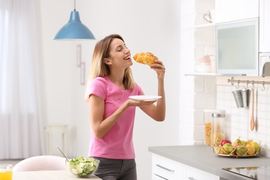Photo of Woman eating dessert in kitchen. Diet failure