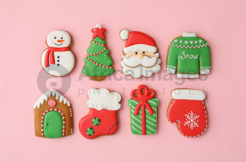 Different Christmas gingerbread cookies on pink background, flat lay