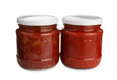 Glass jars of delicious canned lecho on white background