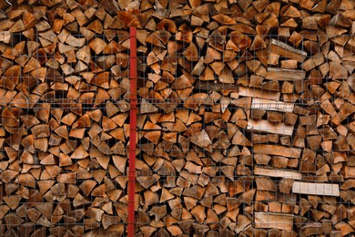Stacked firewood as background. Heating house in winter