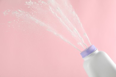 Photo of Scattering of dusting powder on pink background