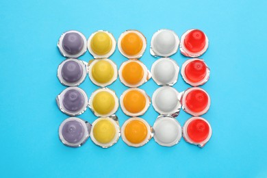 Tasty bright jelly cups on light blue background, flat lay