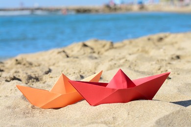 Photo of Two paper boats near sea on sunny day
