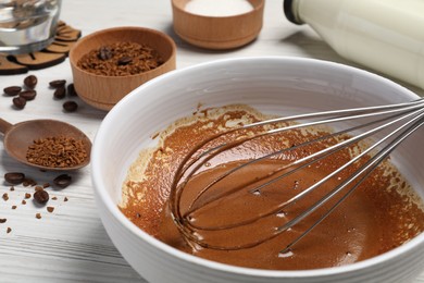 Photo of Whipping cream from instant coffee granules and ingredients on white table, closeup