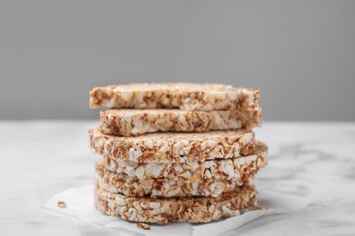 Stack of crunchy buckwheat cakes on white marble table, closeup