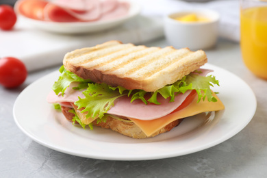 Tasty sandwich with ham on grey table