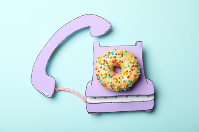 Vintage phone made with donut on light blue background, top view