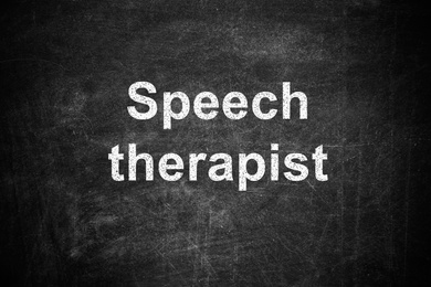 Text Speech Therapist written on dirty black chalkboard 