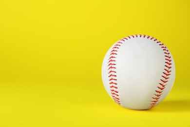 Photo of Baseball ball on yellow background, closeup with space for text. Sports game