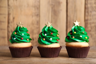 Christmas tree shaped cupcakes on wooden table