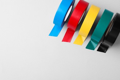 Colorful insulating tapes on white background, flat lay. Space for text