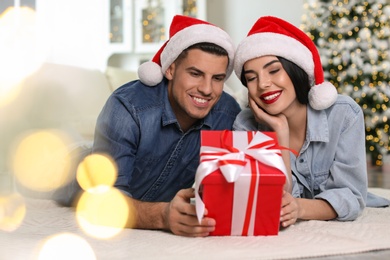 Happy couple with Christmas gift box at home
