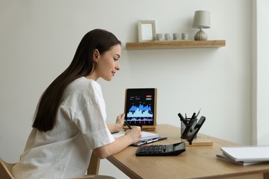 Businesswoman working with tablet in office. Forex trading