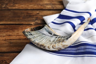 Photo of Shofar and Tallit on wooden table. Rosh Hashanah holiday attributes