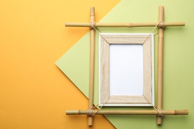Empty bamboo frame on color background, top view. Space for text