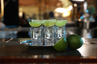 Mexican Tequila shots with lime slices on bar counter
