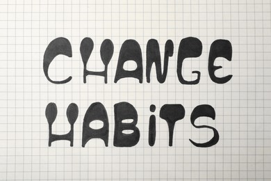 Phrase Change Habits written on gridded paper, top view