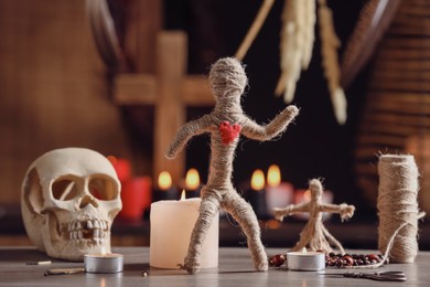 Voodoo doll with heart and ceremonial items on wooden table