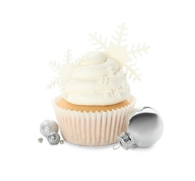 Tasty cupcake with snowflakes and Christmas baubles on white background