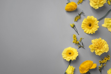 Color of the year 2021. Beautiful yellow flowers and space for text on grey background, flat lay