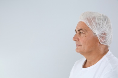 Portrait of senior man with marks on face preparing for cosmetic surgery against white background. Space for text