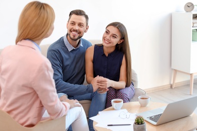 Female real estate agent working with couple in office