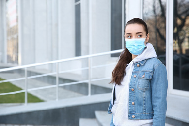 Woman wearing disposable mask outdoors. Dangerous virus