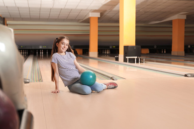 Preteen girl with ball in bowling club