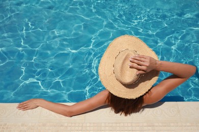 Woman wearing hat in swimming pool, above view