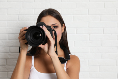 Professional photographer working near white brick wall in studio. Space for text