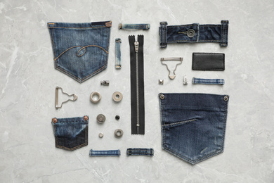 Photo of Flat lay composition with garment accessories and cutting details for jeans on grey marble background