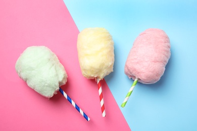 Straws with yummy cotton candy on color background, top view