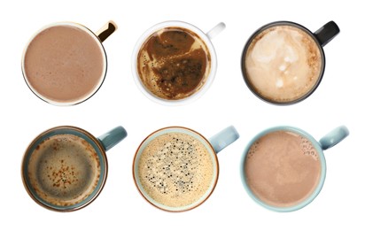 Set of mugs with tasty hot drinks on white background, top view