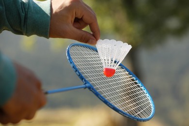 Man playing badminton outdoors on sunny day, closeup