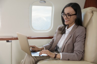 Businesswoman working on laptop in airplane during flight