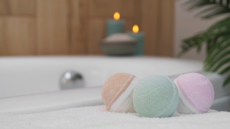 Colorful bath bombs on white towel in bathroom. Space for text
