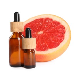 Bottles of citrus essential oil and fresh grapefruit on white background