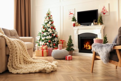 Photo of Stylish living room interior with TV set, Christmas tree and fireplace