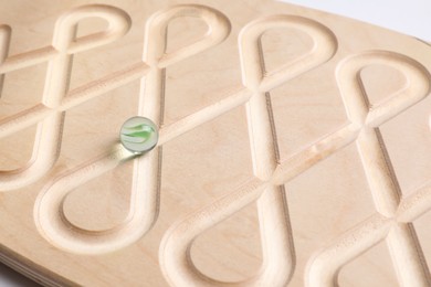 Photo of Wooden labyrinth balance board on white background, closeup. Montessori toy