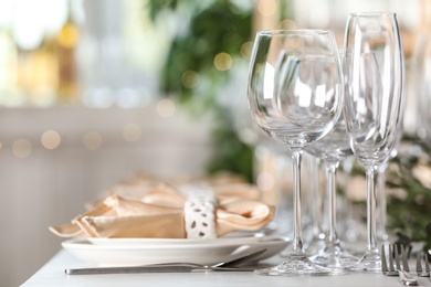 Table setting with empty glasses, plates and cutlery indoors
