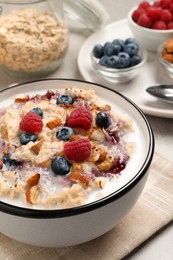 Tasty oatmeal porridge with toppings served on grey table, closeup